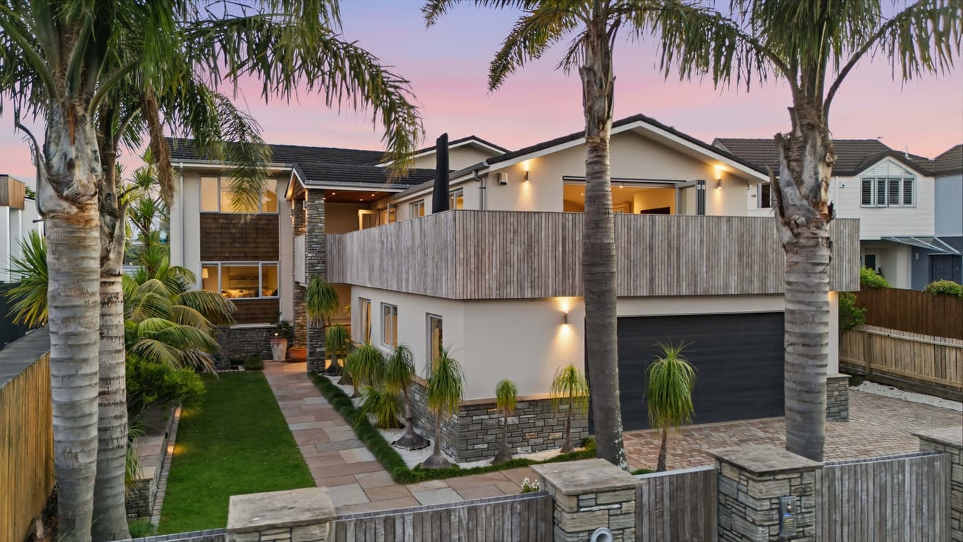 Twilight street frontage framed by palms