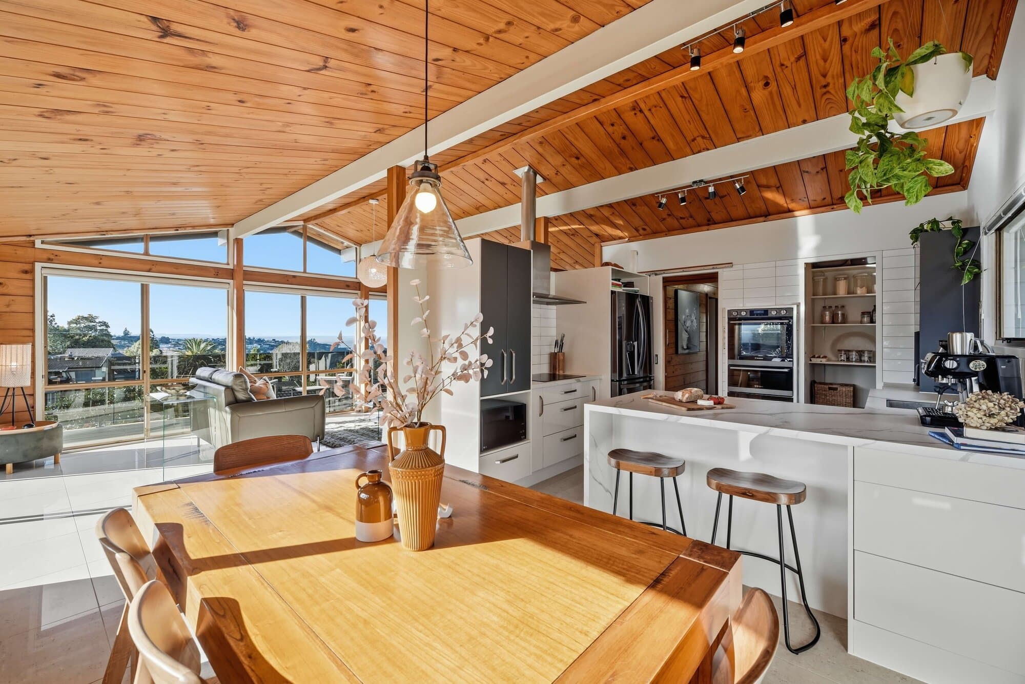 Kitchen and dining space with sea view beyond and pendant lights