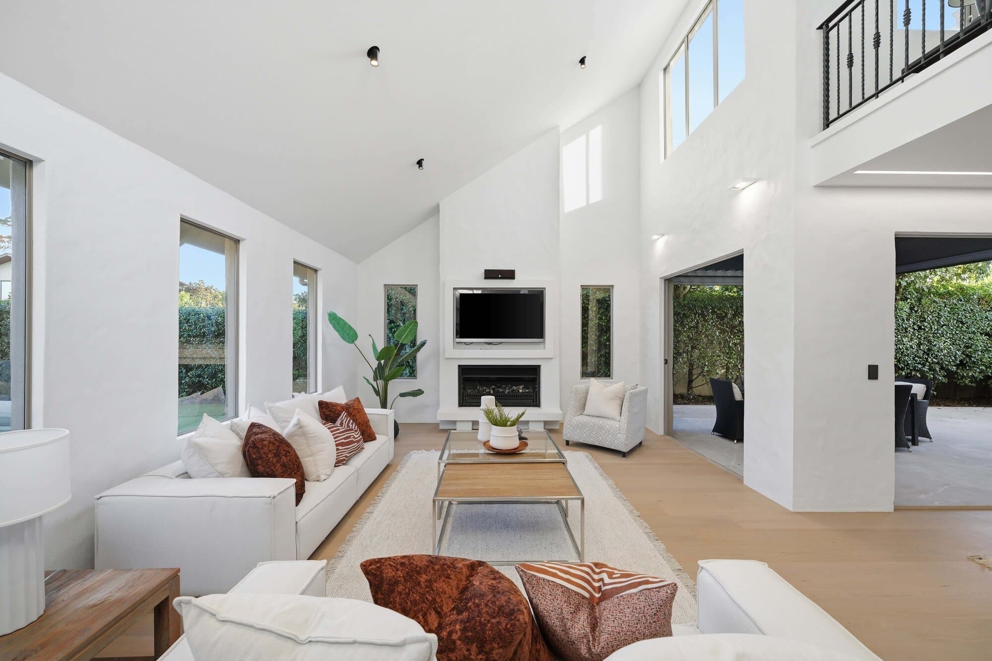 Living room with fireplace beneath a soaring void ceiling