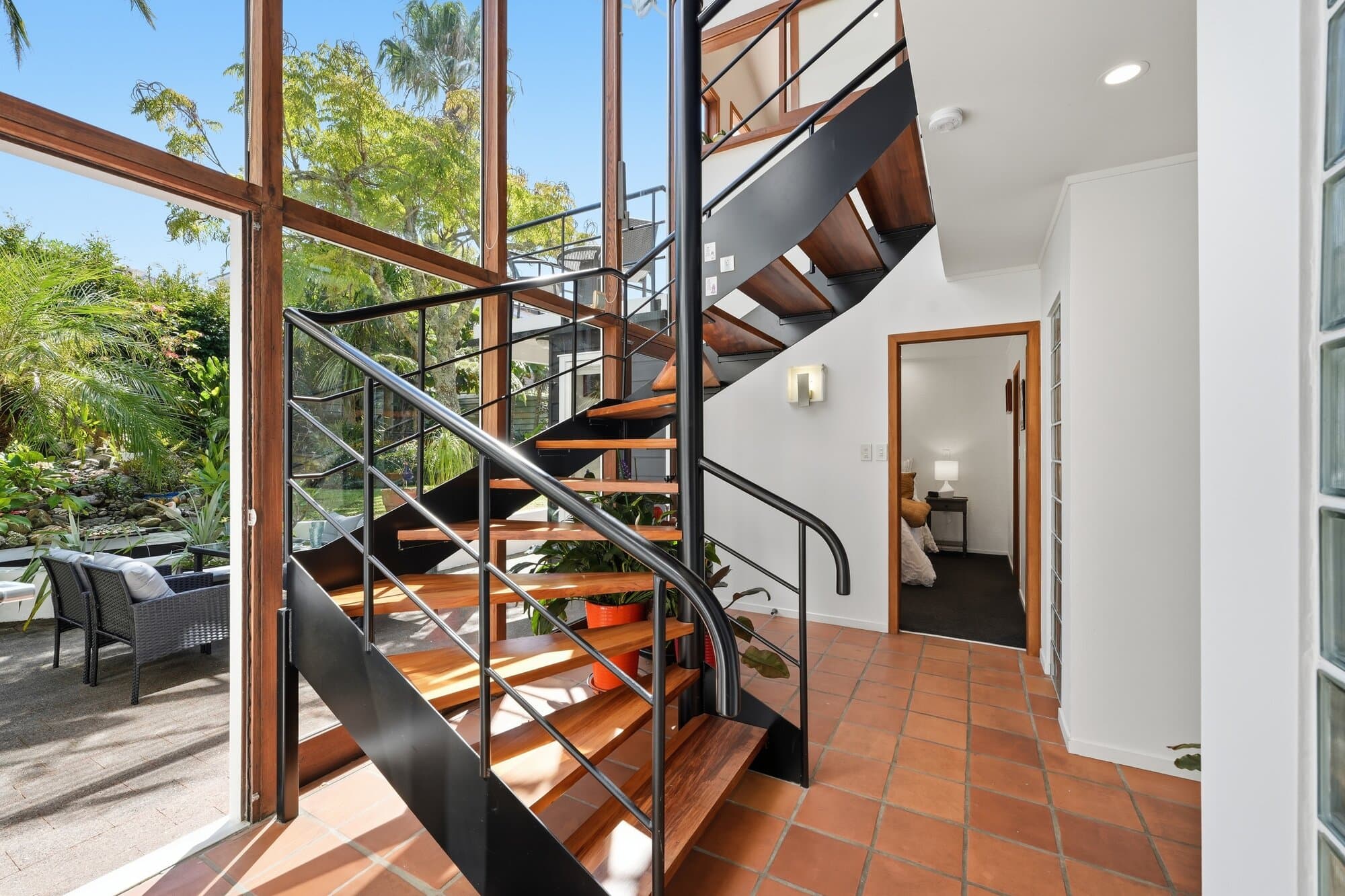 Spiral staircase behind a full-height glass wall