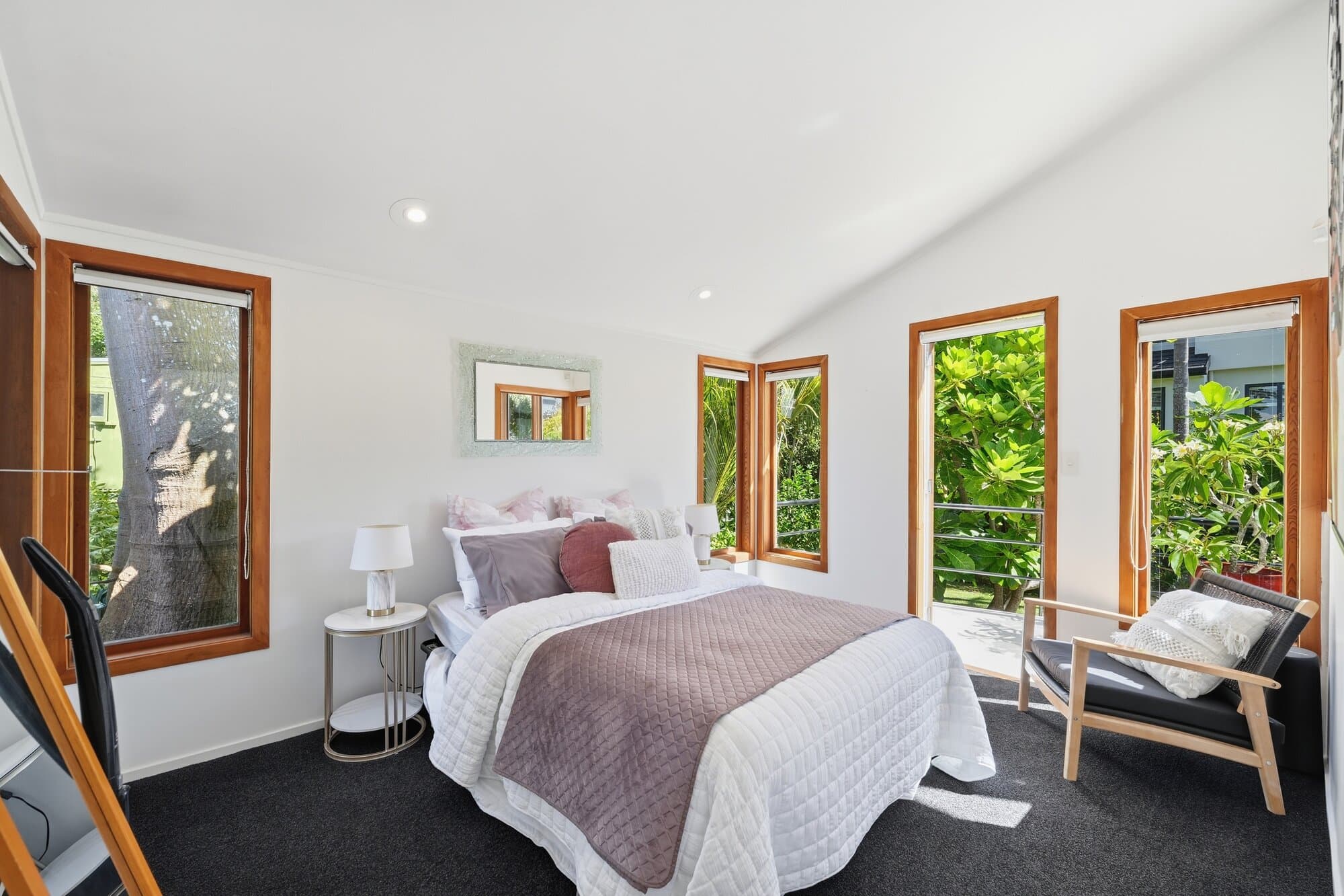 Second bedroom with timber-framed windows and colourful bedding