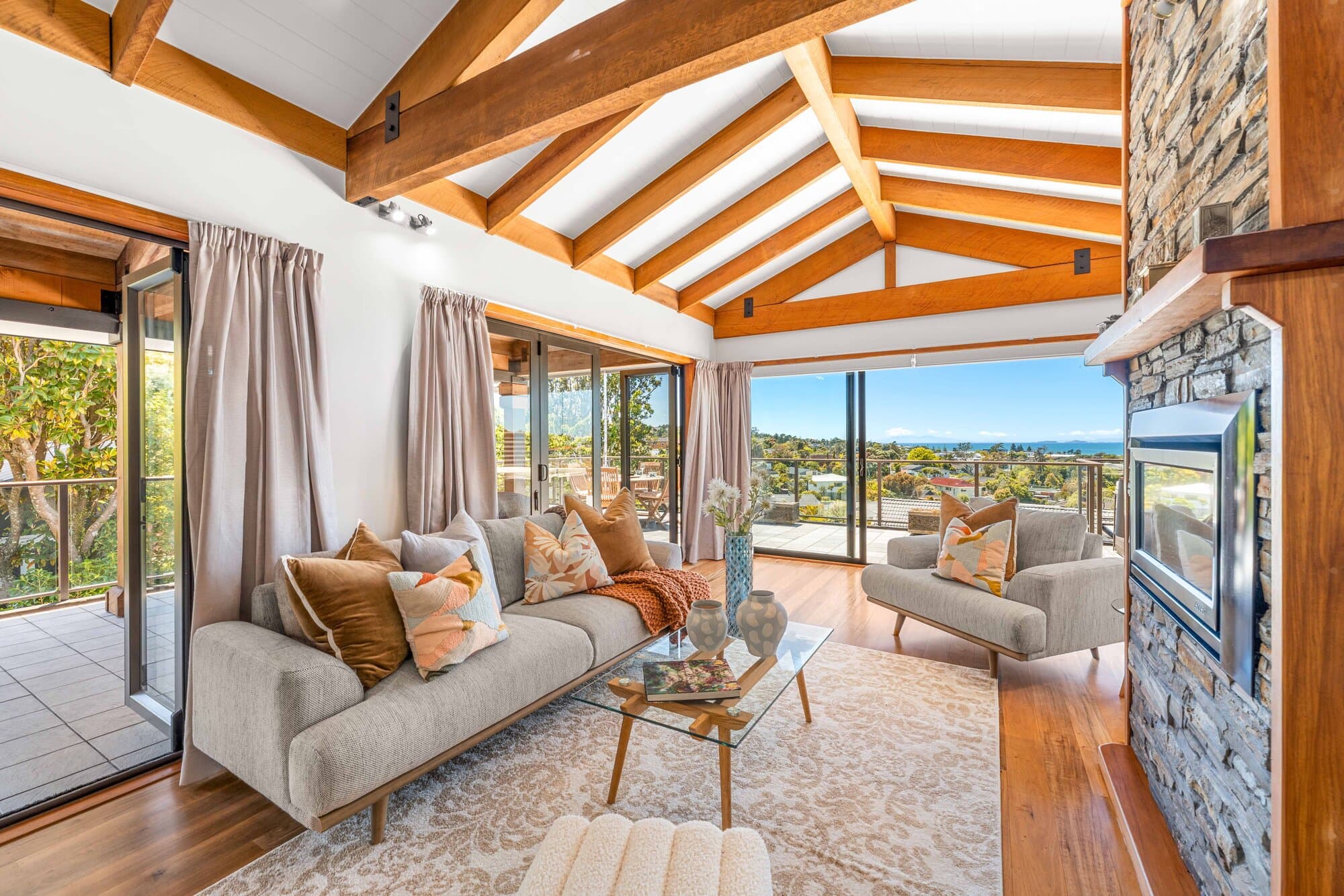 Living room with vaulted timber ceiling and stone fireplace