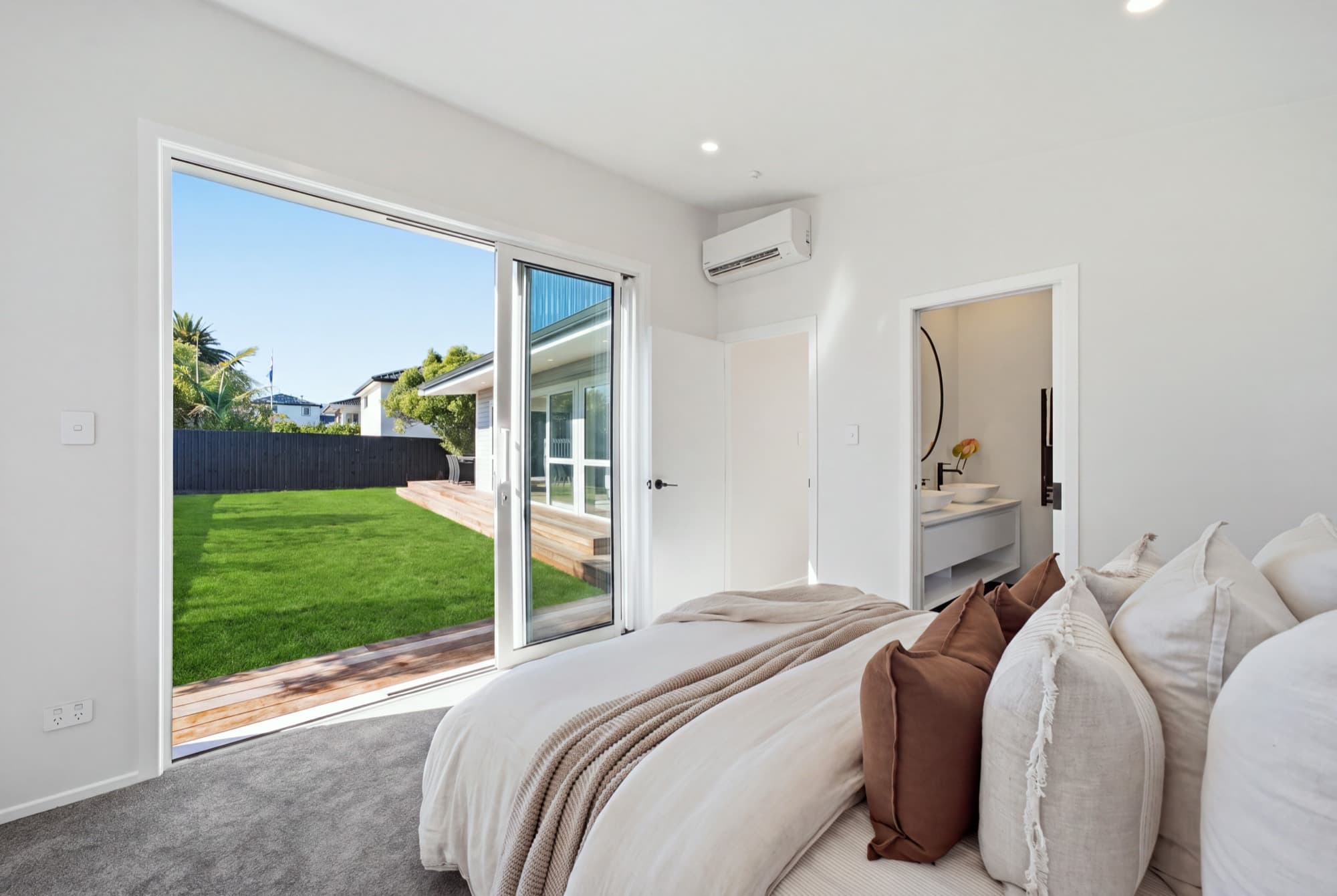 Primary bedroom with an ensuite and sliding doors onto the lawn