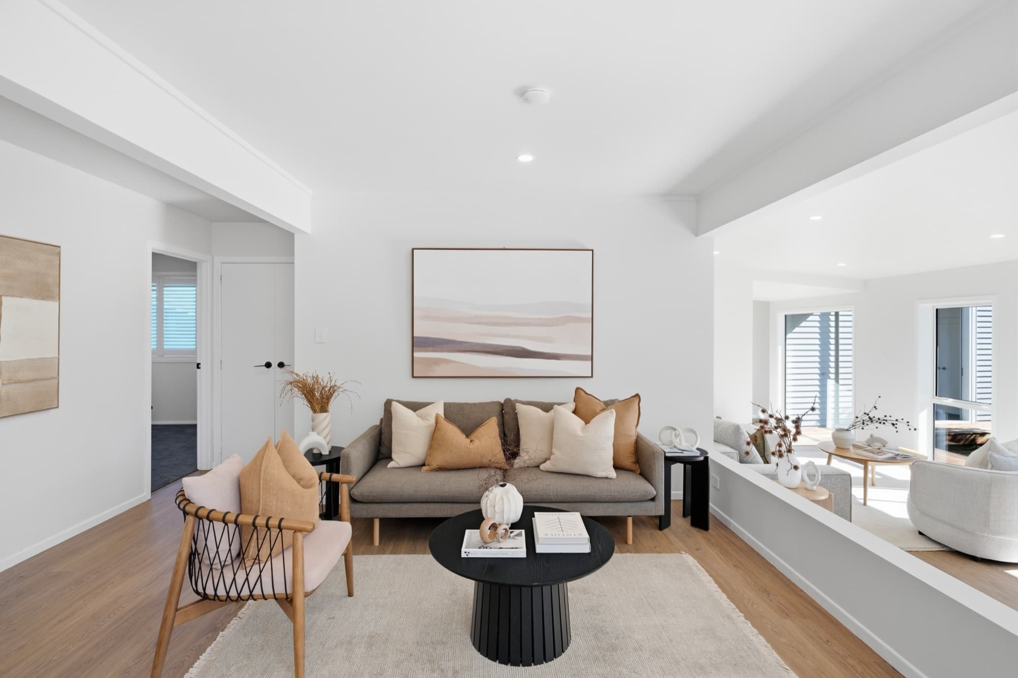 Second living area in a soft neutral palette, opening through to the family room