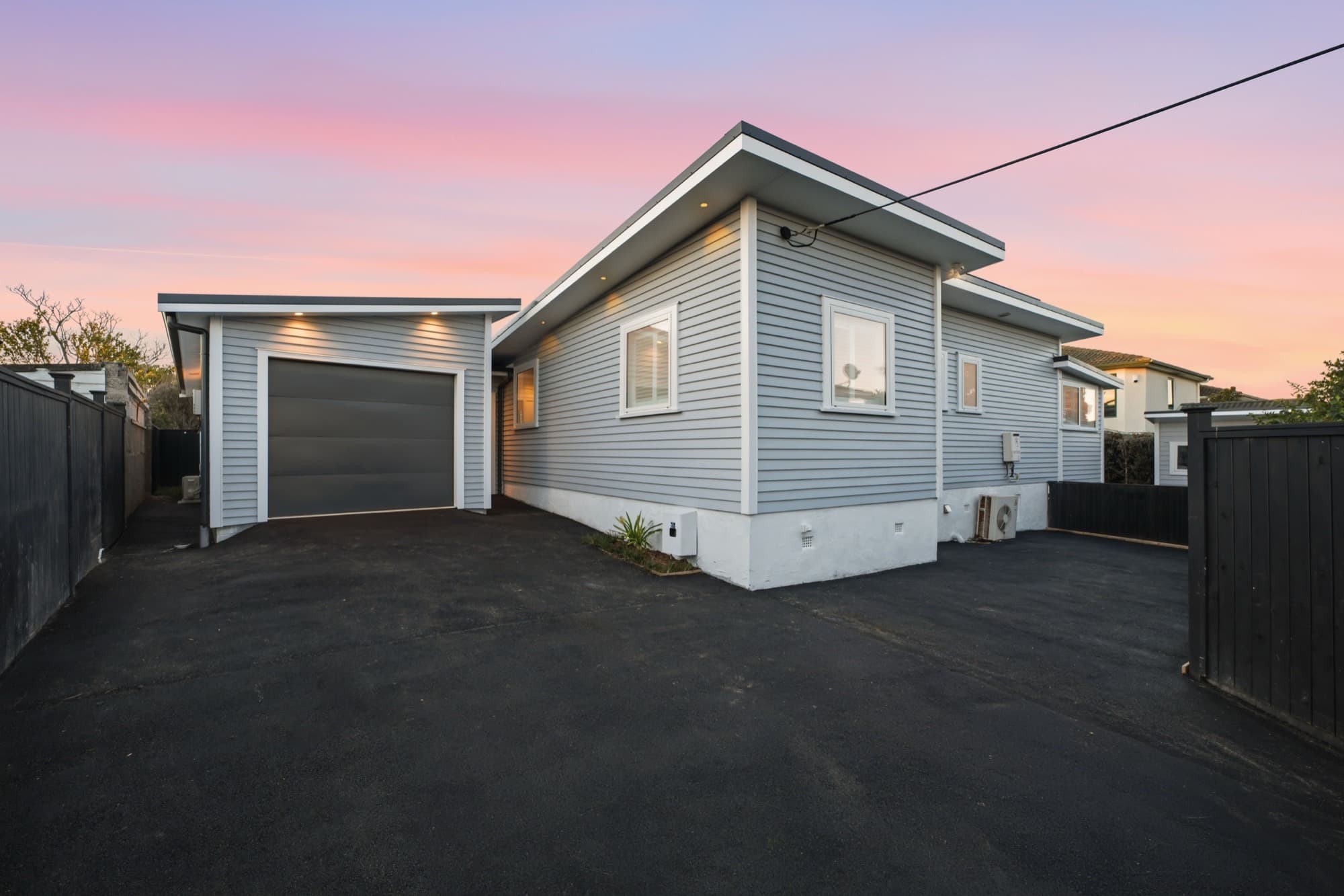 Garage and driveway at twilight alongside the house