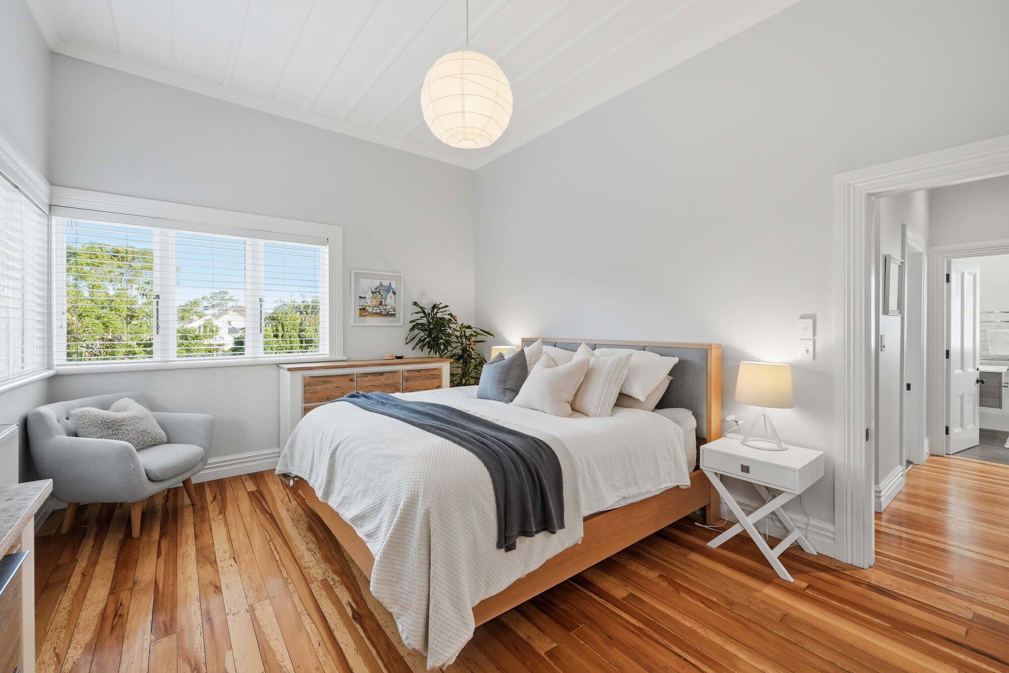 Bedroom with timber flooring and a high ceiling